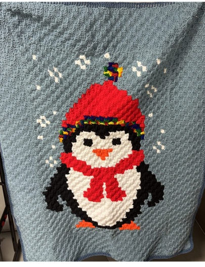 A crocheted blanket with a penguin design